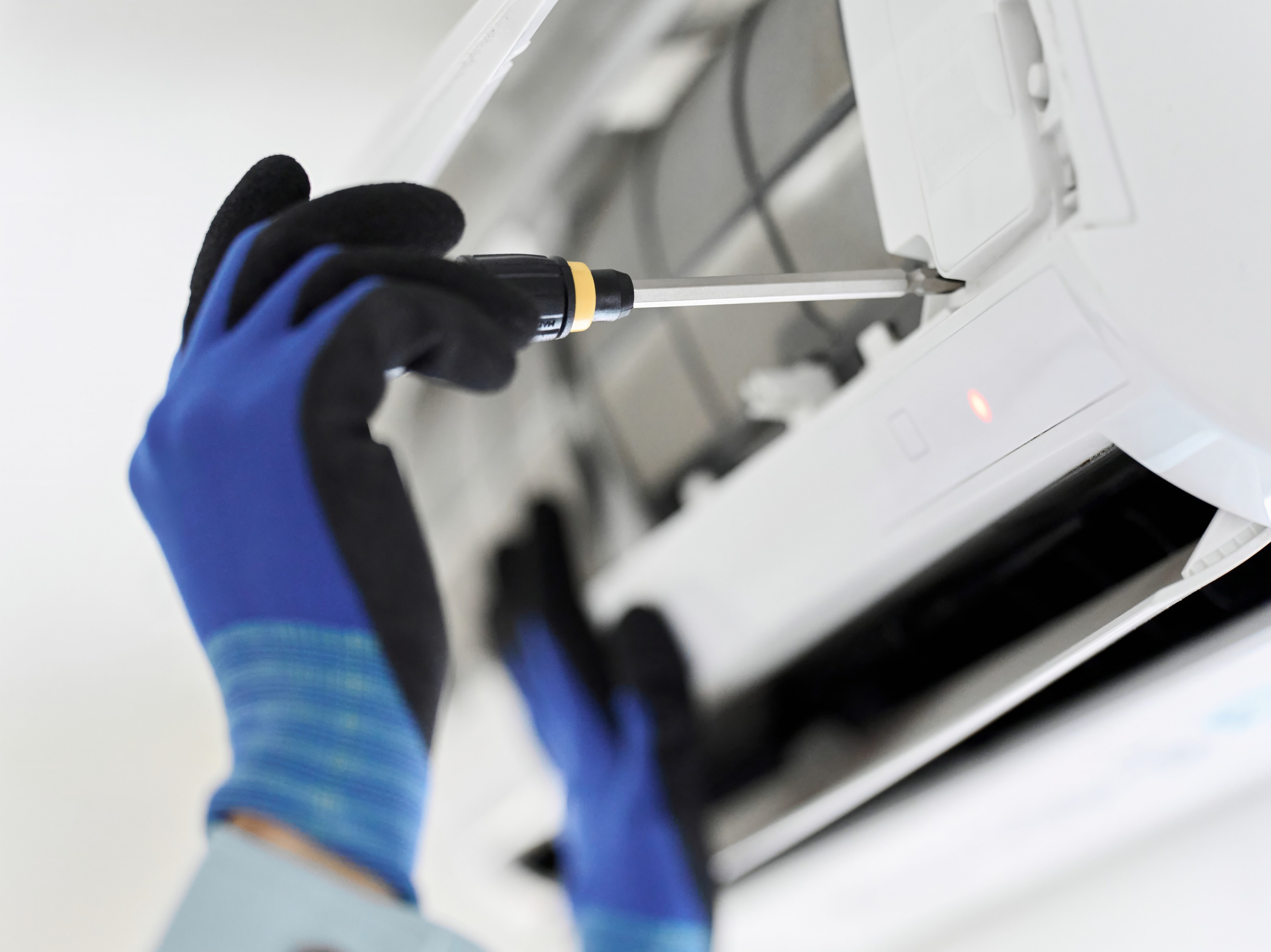 エアコンの点検をするアジア人の作業員